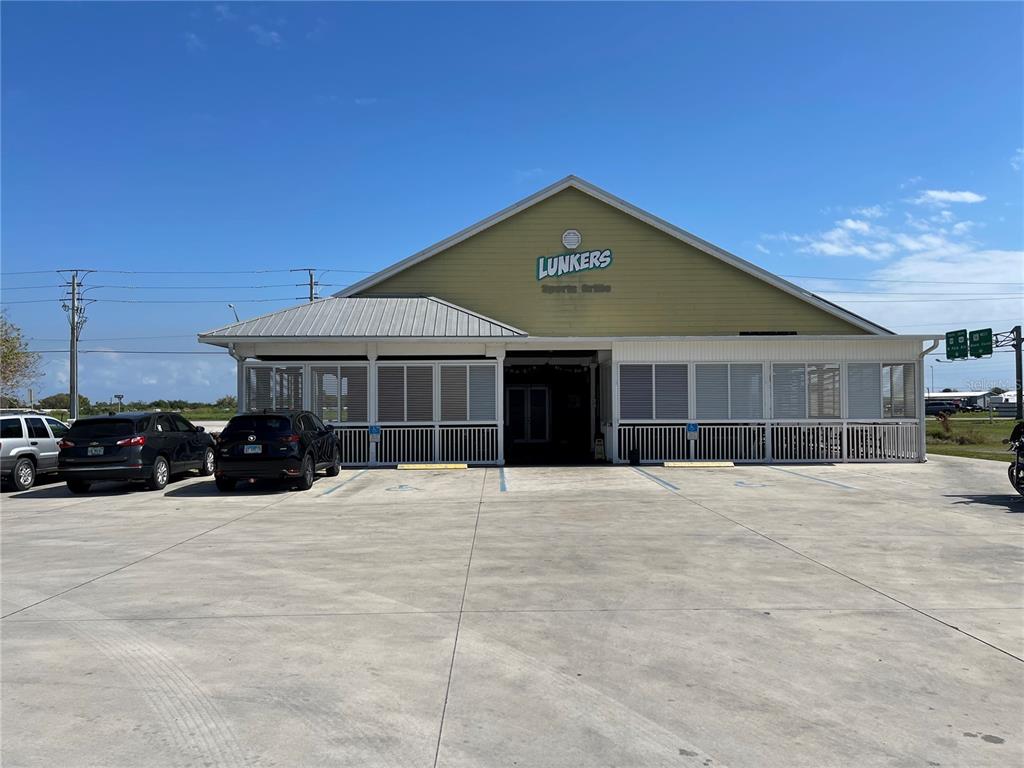 A light green building with a covered patio and parking lot under a blue sky — 4825 S U S 441 HIGHWAY S, OKEECHOBEE, FL