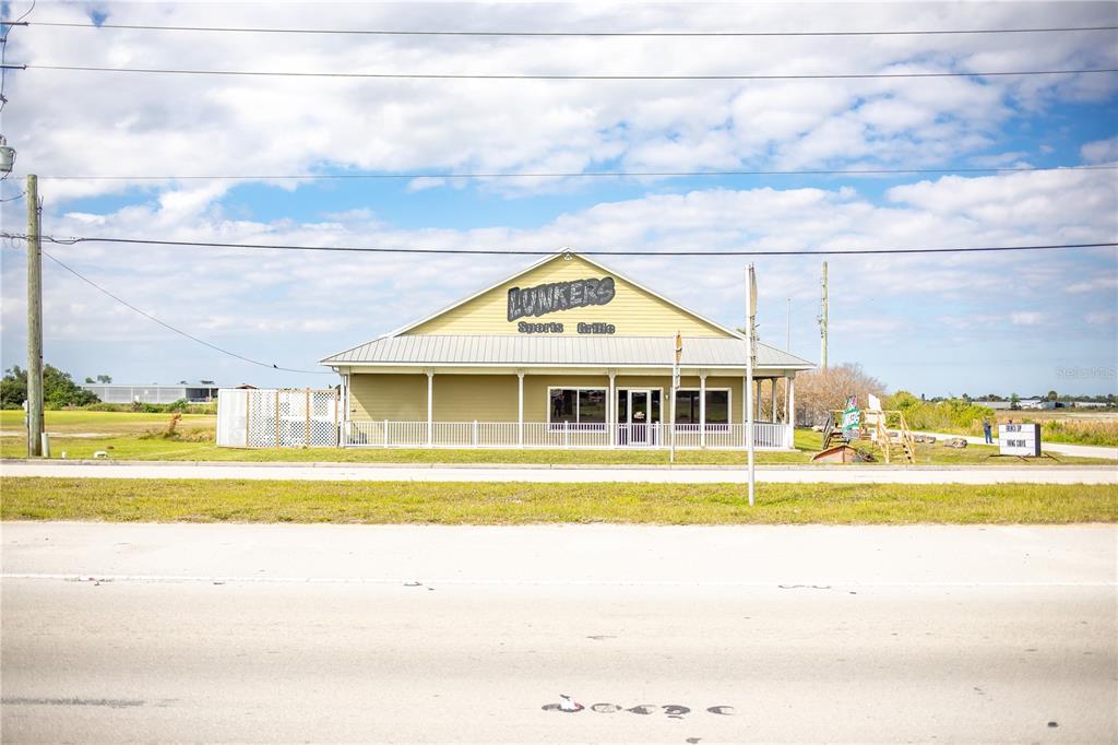 A light green, single-story commercial building with a metal roof and a front porch — 4825 S U S 441 HIGHWAY S, OKEECHOBEE, FL