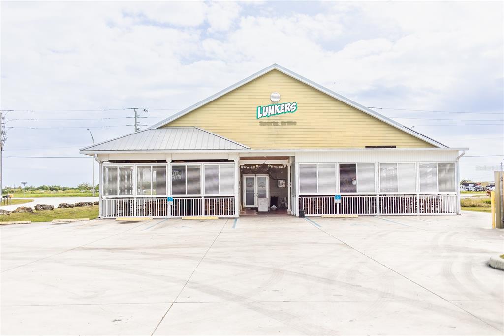 A yellow, single-story commercial building with a covered porch and a large concrete parking lot — 4825 S U S 441 HIGHWAY S, OKEECHOBEE, FL