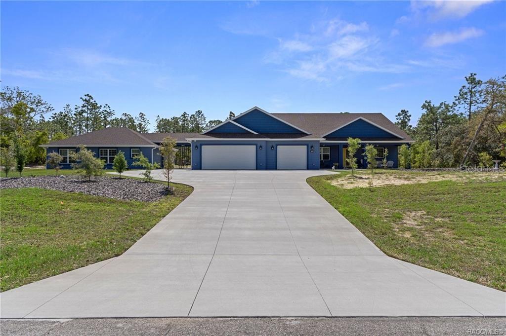 A blue house with a three-car garage and a long concrete driveway — 4999 N TEE PEE DRIVE, BEVERLY HILLS, FL