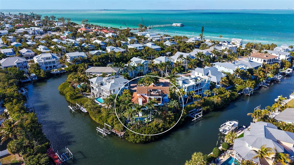 An aerial view of a waterfront house surrounded by lush trees and a canal — 513 VILLA ROSA WAY, ANNA MARIA, FL