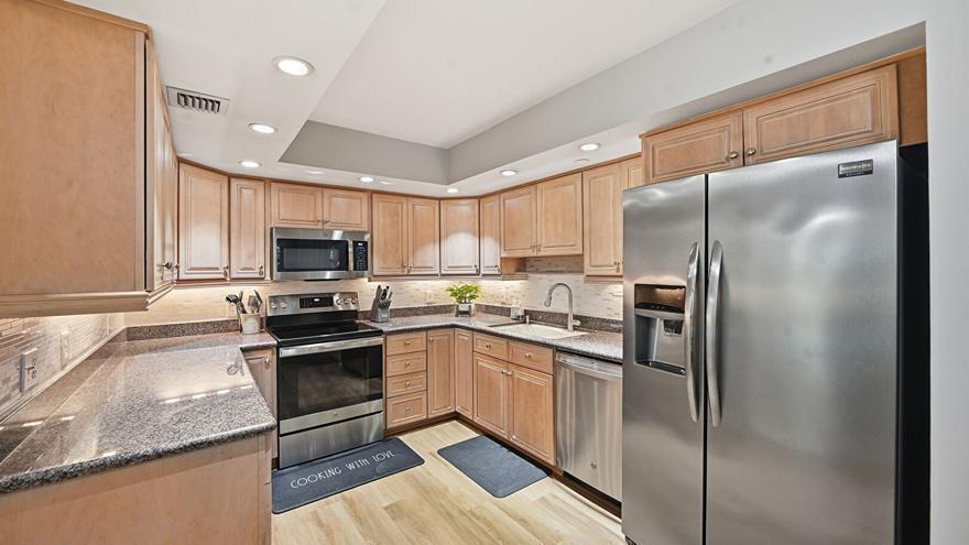 A kitchen features light wood cabinets, granite countertops, stainless steel appliances, and recessed lighting — 500 Ocean Trail Way # 207, Jupiter FL 33477, JUPITER, FL