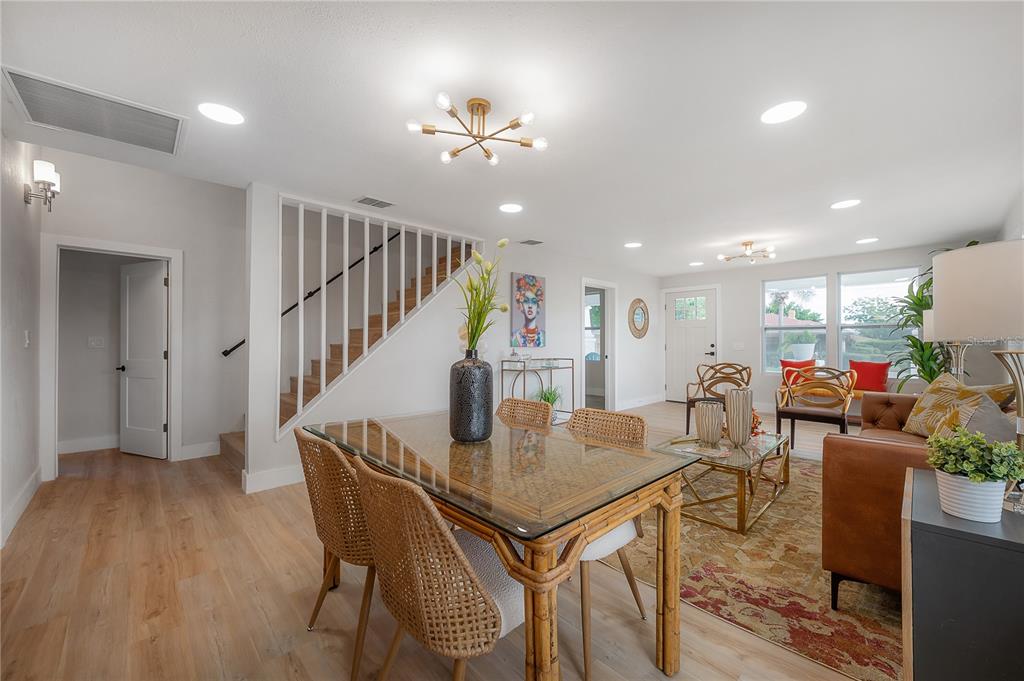 A dining area with a glass-topped rattan table sits adjacent to a living room — 2702 W PALMETTO STREET, TAMPA, FL