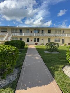 A concrete walkway leads to the entrance of a two-story apartment building with balconies — 321 Northampton, West Palm Beach FL 33417, WEST PALM BEACH, FL