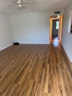An empty room with wood-look flooring, a ceiling fan, and a doorway leading to another room — 321 Northampton, West Palm Beach FL 33417, WEST PALM BEACH, FL