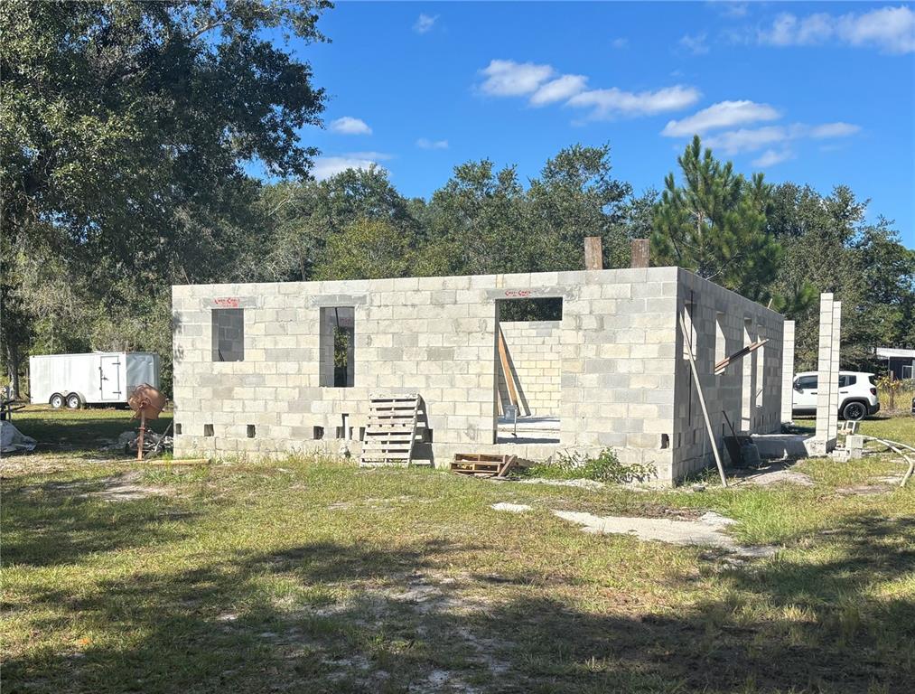 A partially constructed concrete block building stands on a grassy lot under a blue sky — 432 WILDLIFE TRAIL, LAKELAND, FL