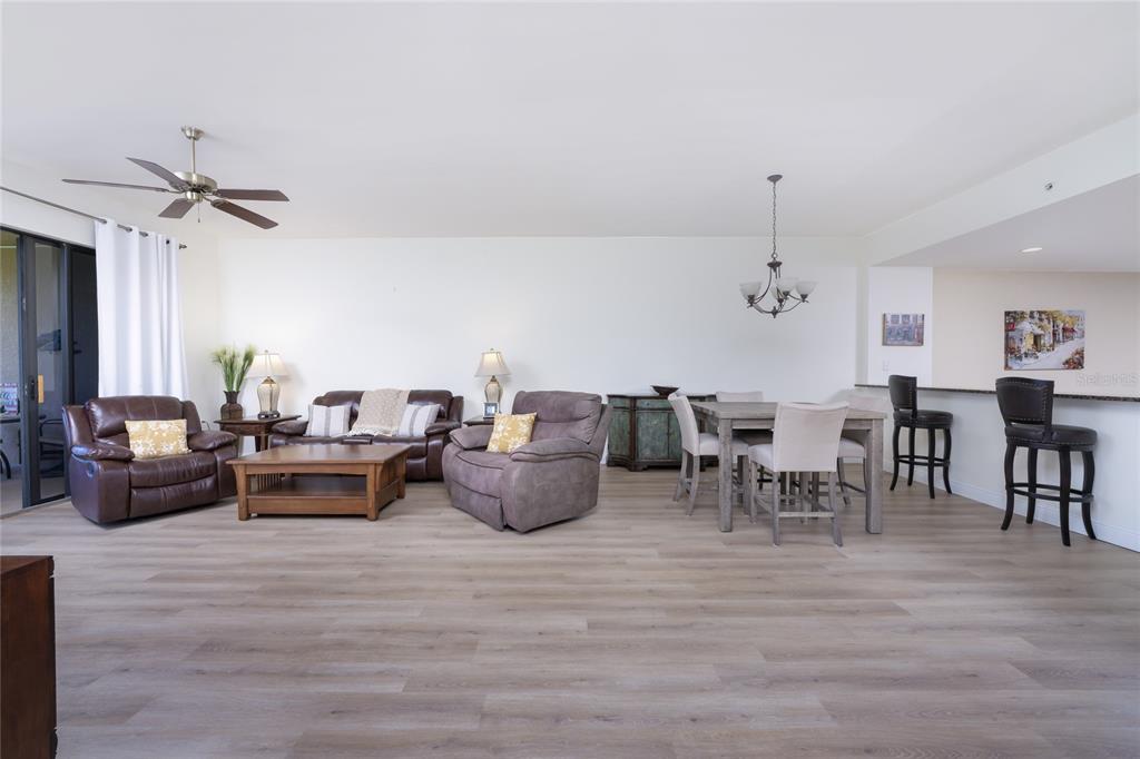 An open-concept living and dining area features light wood-look flooring and neutral walls — 85 VIVANTE BOULEVARD UNIT 8524, PUNTA GORDA, FL