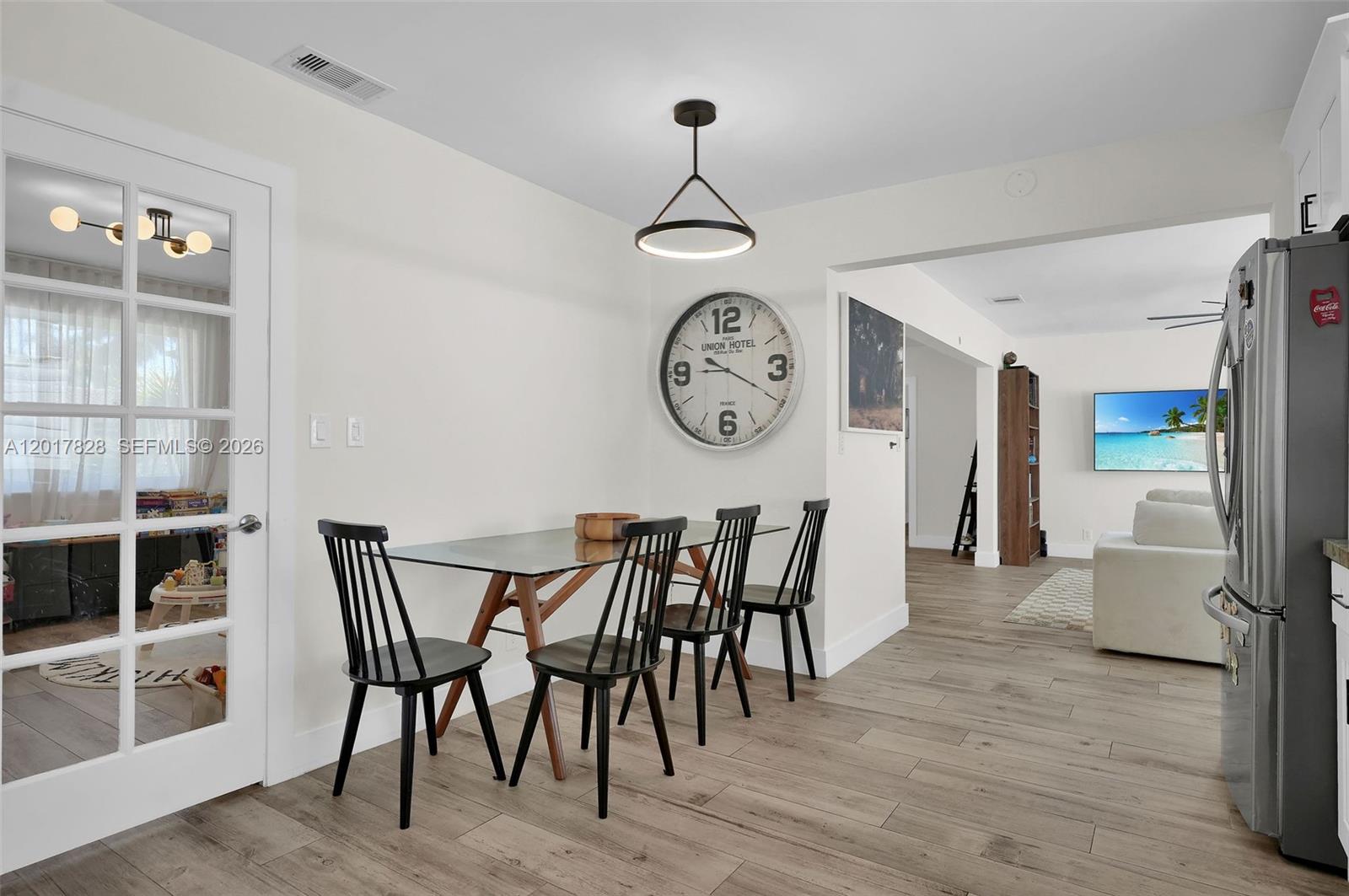 A dining area features a glass table, four black chairs, and a large wall clock — 1301 Hollywood Blvd, Hollywood FL 33019, HOLLYWOOD, FL