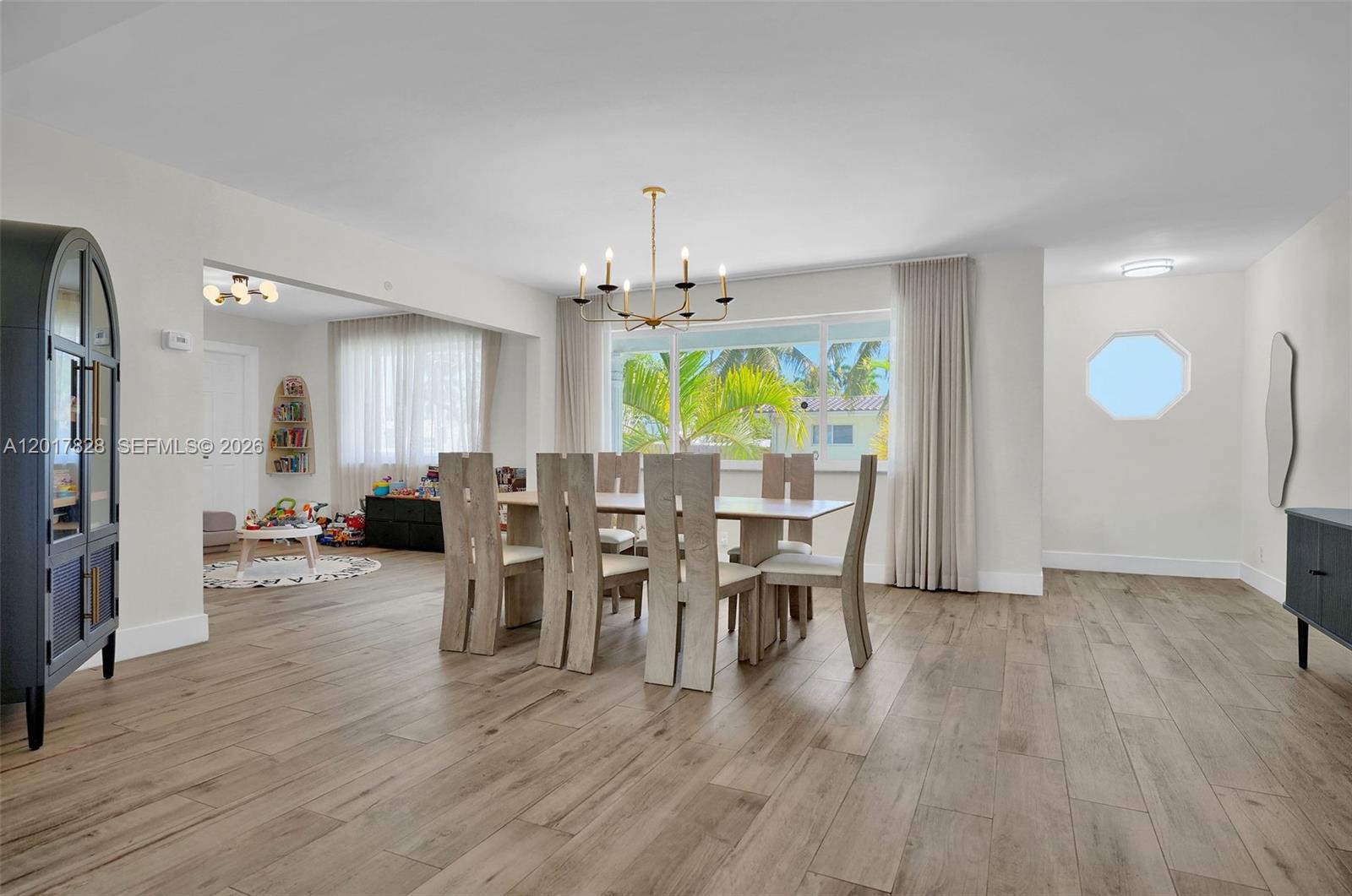 A dining room features a wooden table, six chairs, a chandelier, and light wood flooring — 1301 Hollywood Blvd, Hollywood FL 33019, HOLLYWOOD, FL
