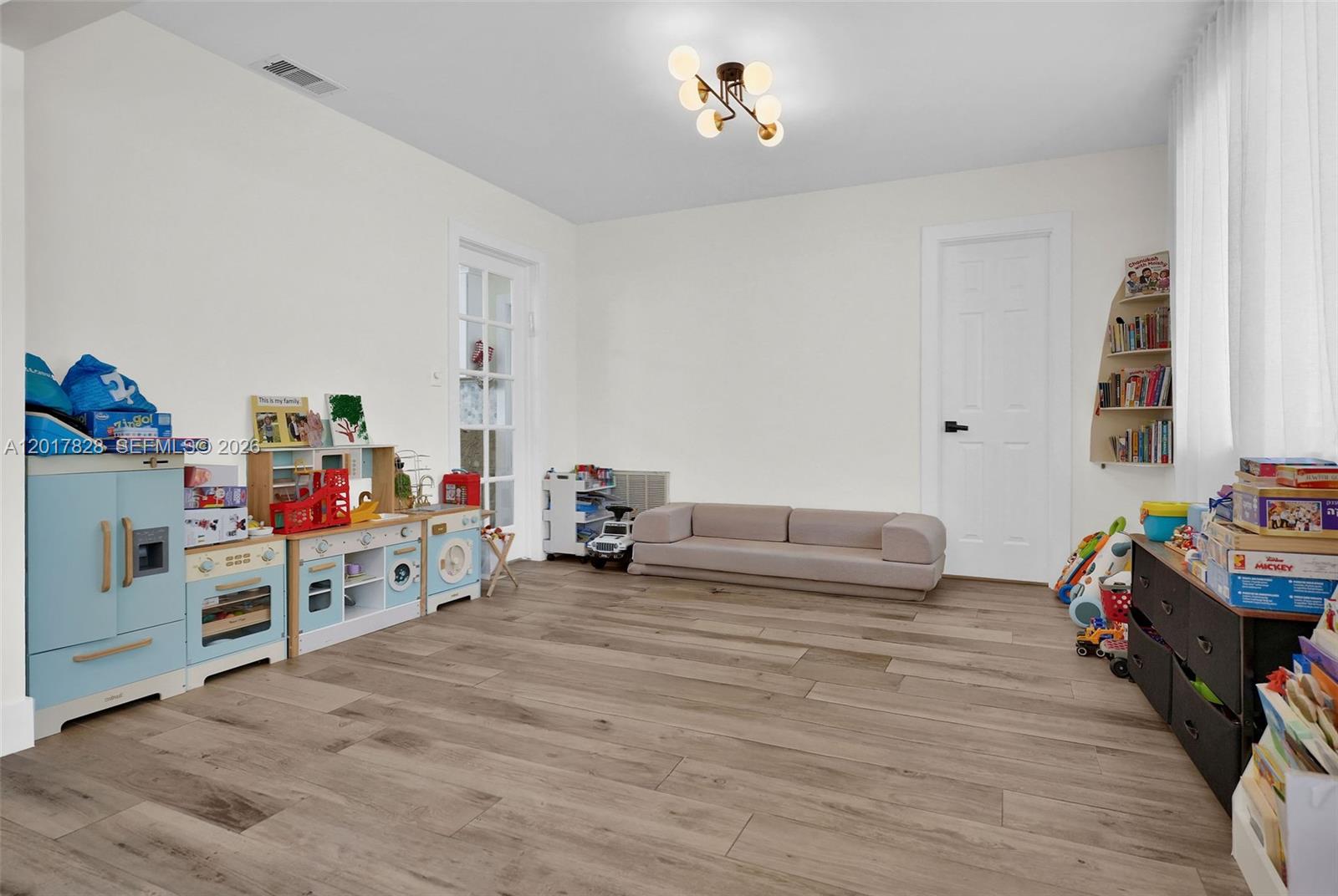 A playroom features light wood-look flooring, a low beige sofa, and various children's toy sets — 1301 Hollywood Blvd, Hollywood FL 33019, HOLLYWOOD, FL