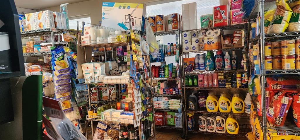 A retail store aisle features metal shelving units stocked with various household goods and groceries — Carr. 414, Km 3.6 BO. RÍO GRANDE, RINCON, PR