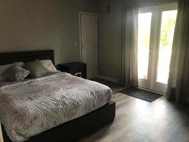 A bedroom features a bed with a patterned comforter, a nightstand, and glass patio doors — 2513 Colleen, Tallahassee FL 32303, TALLAHASSEE, FL