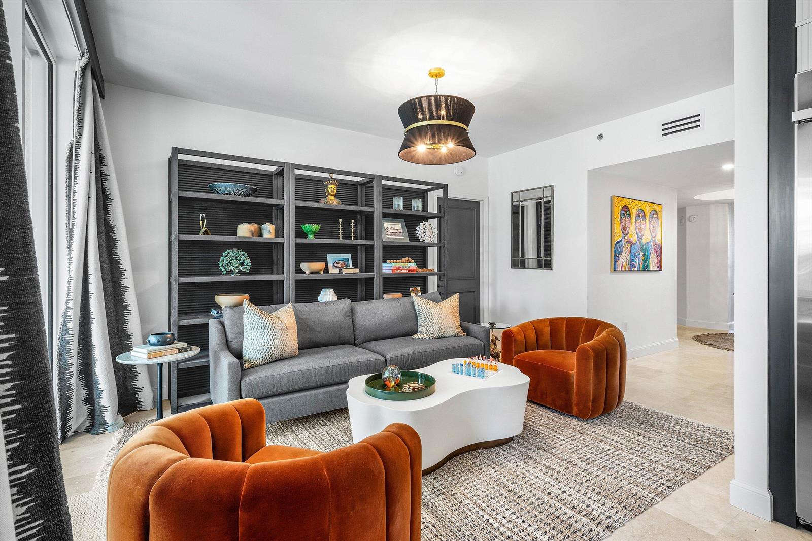 A living room features a grey sofa, two orange velvet armchairs, and a large bookshelf — 3700 S Ocean Boulevard # 202, Highland Beach FL 33487, HIGHLAND BEACH, FL