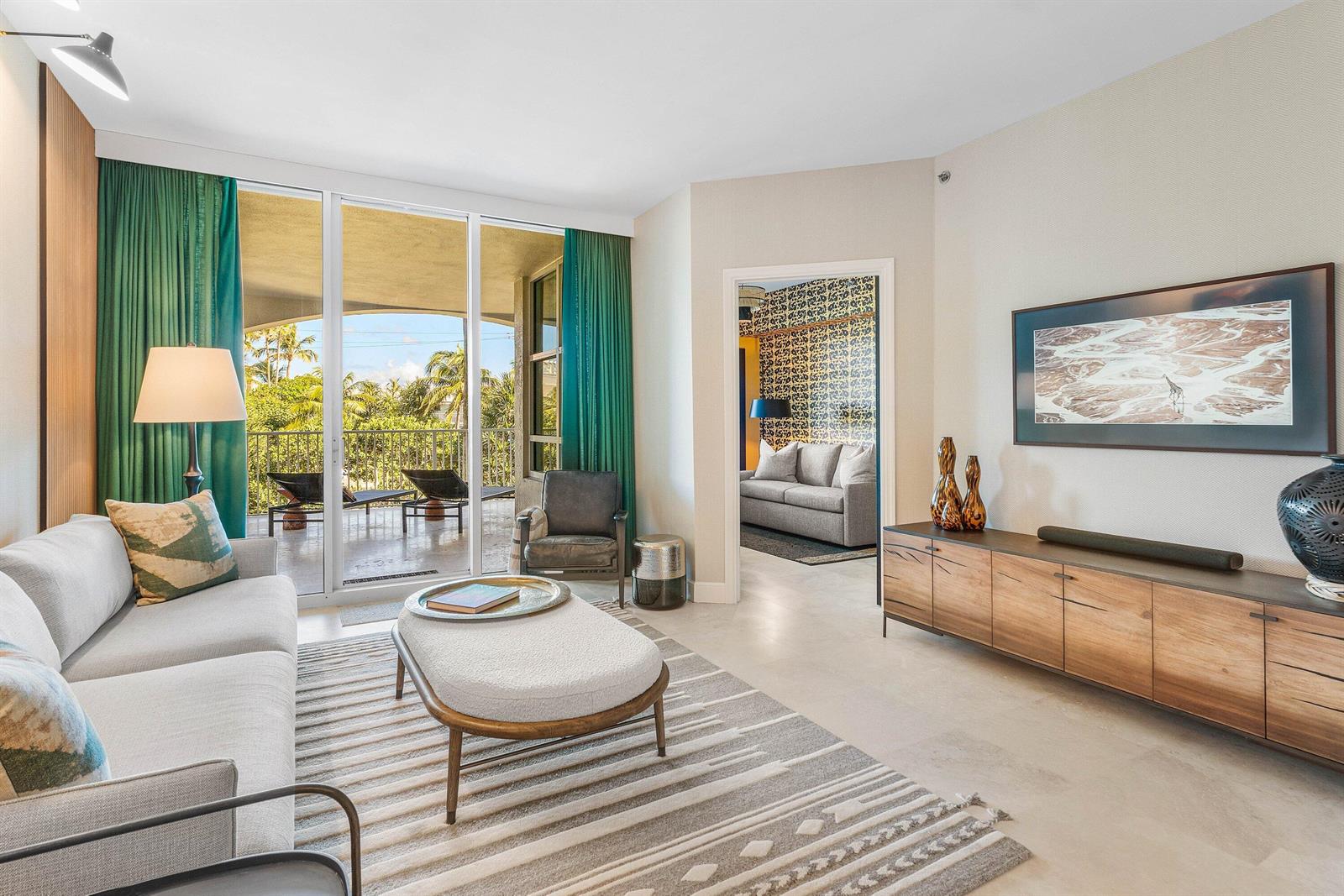 A living room features a light gray sofa, a patterned rug, and a balcony view — 3700 S Ocean Boulevard # 202, Highland Beach FL 33487, HIGHLAND BEACH, FL