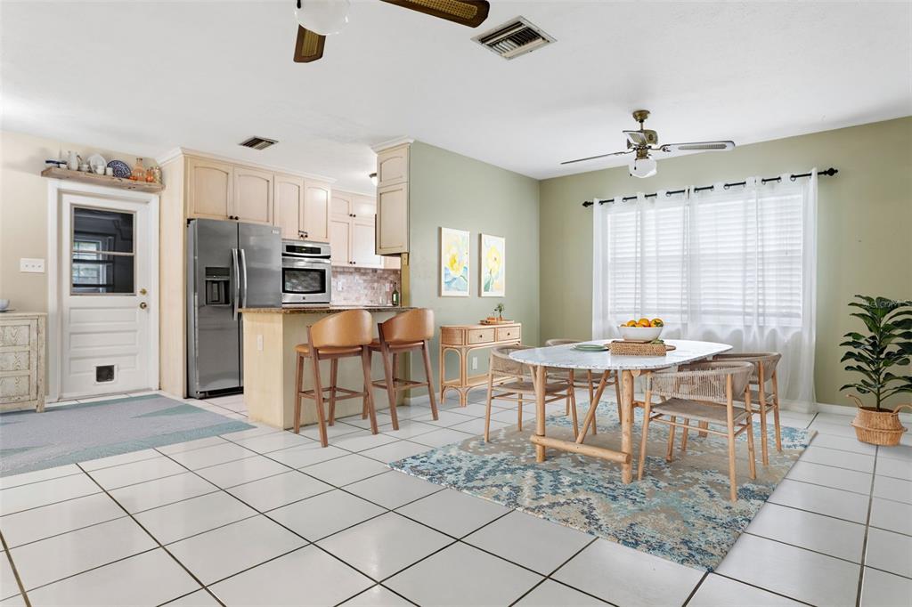 A kitchen and dining area with tile floors, light wood cabinets, and a ceiling fan — 2801 WILSON CIRCLE, LUTZ, FL