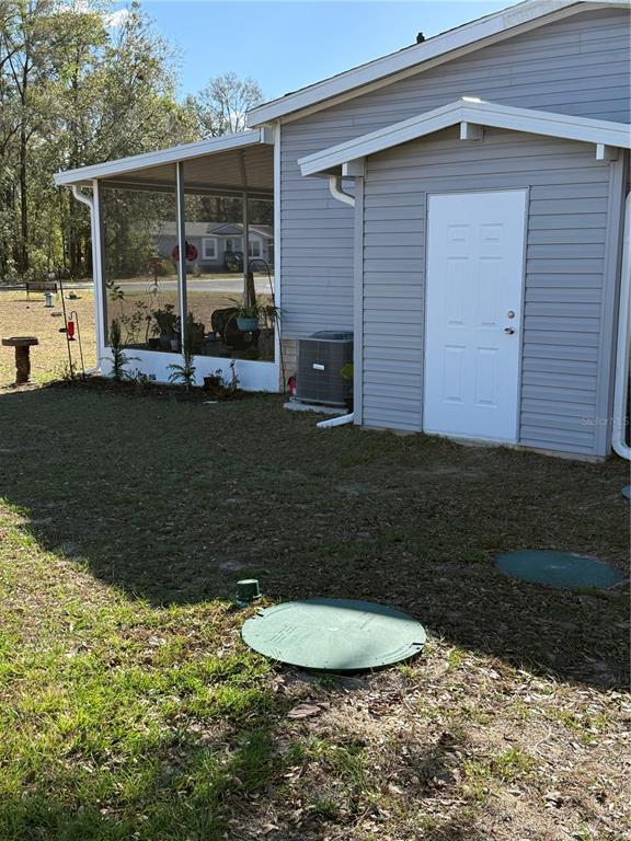 A single-story manufactured home with grey siding and a brick foundation sits on a lot — 8325 N FAIRGROVE TERRACE, DUNNELLON, FL