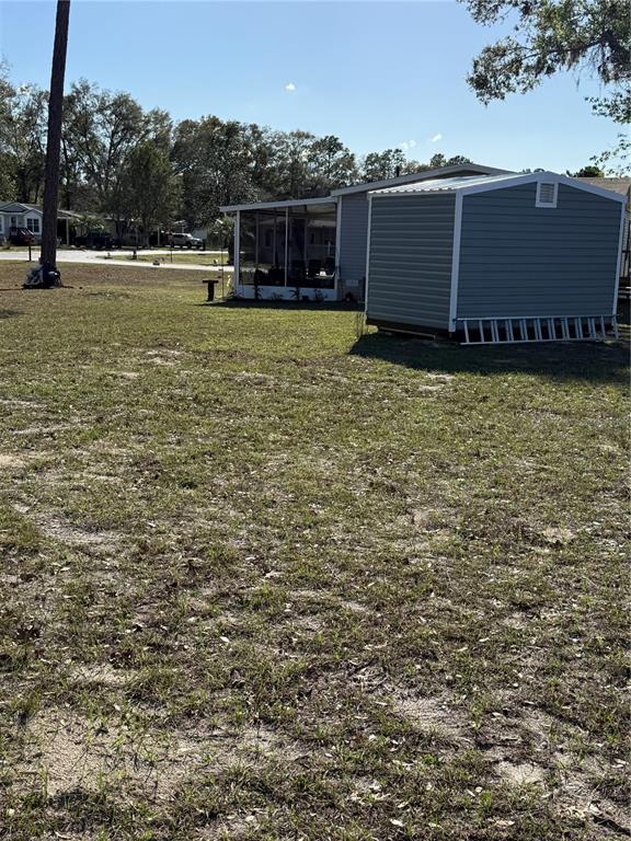 A light green shed with a single door and two windows sits on concrete blocks — 8325 N FAIRGROVE TERRACE, DUNNELLON, FL