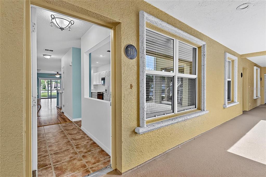 An exterior view of a building entrance with a tiled floor and a large window — 700 CANOPY WALK LANE UNIT 713, PALM COAST, FL