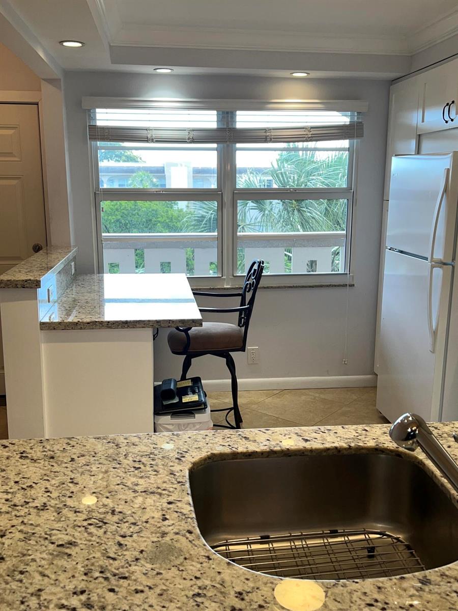A kitchen featuring granite countertops, a stainless steel sink, and a window with outdoor views — 2202 Lucaya Bend # C4, Coconut Creek FL 33066, COCONUT CREEK, FL