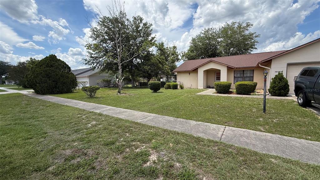 A single-story house with a tan exterior, a brown roof, and a front lawn — 15165 SW 39TH CIRCLE, OCALA, FL