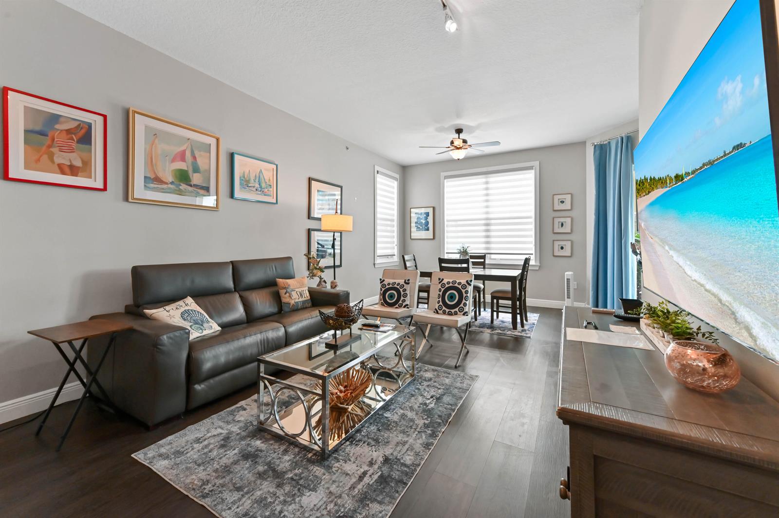 A living room with a dark leather sofa, glass coffee table, and dining area — 804 E Windward Way # 120, Lantana FL 33462, LANTANA, FL