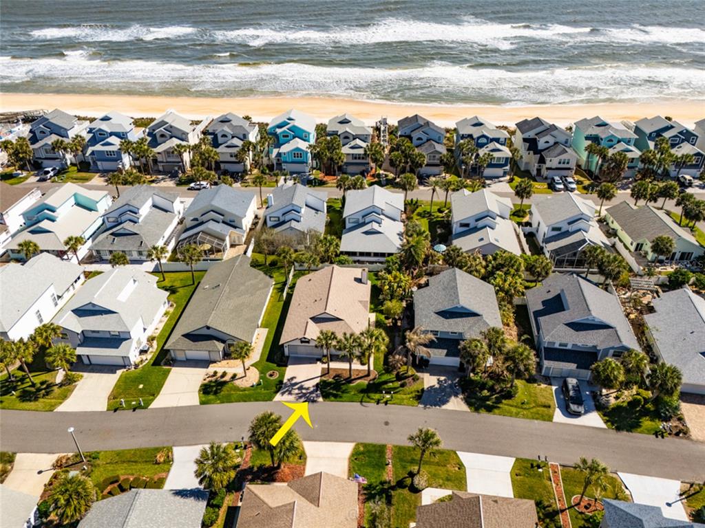 An aerial view shows a residential street with houses near a sandy beach and ocean — 9 SEA VISTA DRIVE, PALM COAST, FL