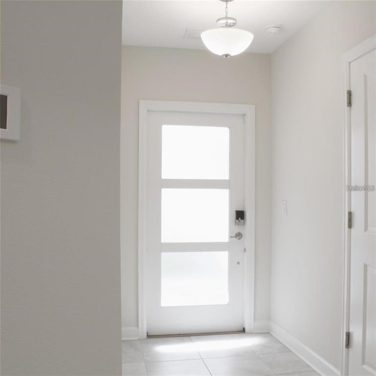An entryway features a white door with three frosted glass panels and a ceiling light — 659 OCEAN COURSE AVENUE UNIT 659, DAVENPORT, FL