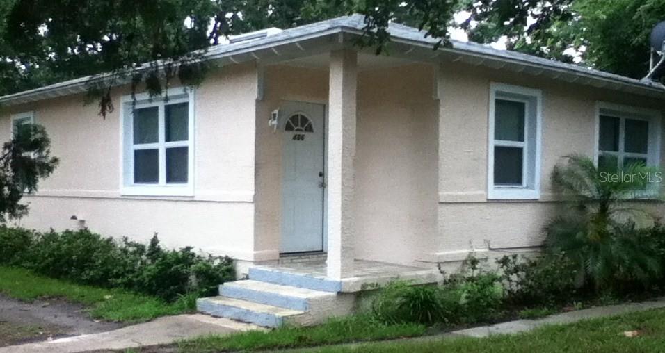 A light-colored, single-story house with a front porch, white trim, and a small set of steps — 486 OAK STREET, NEW SMYRNA BEACH, FL