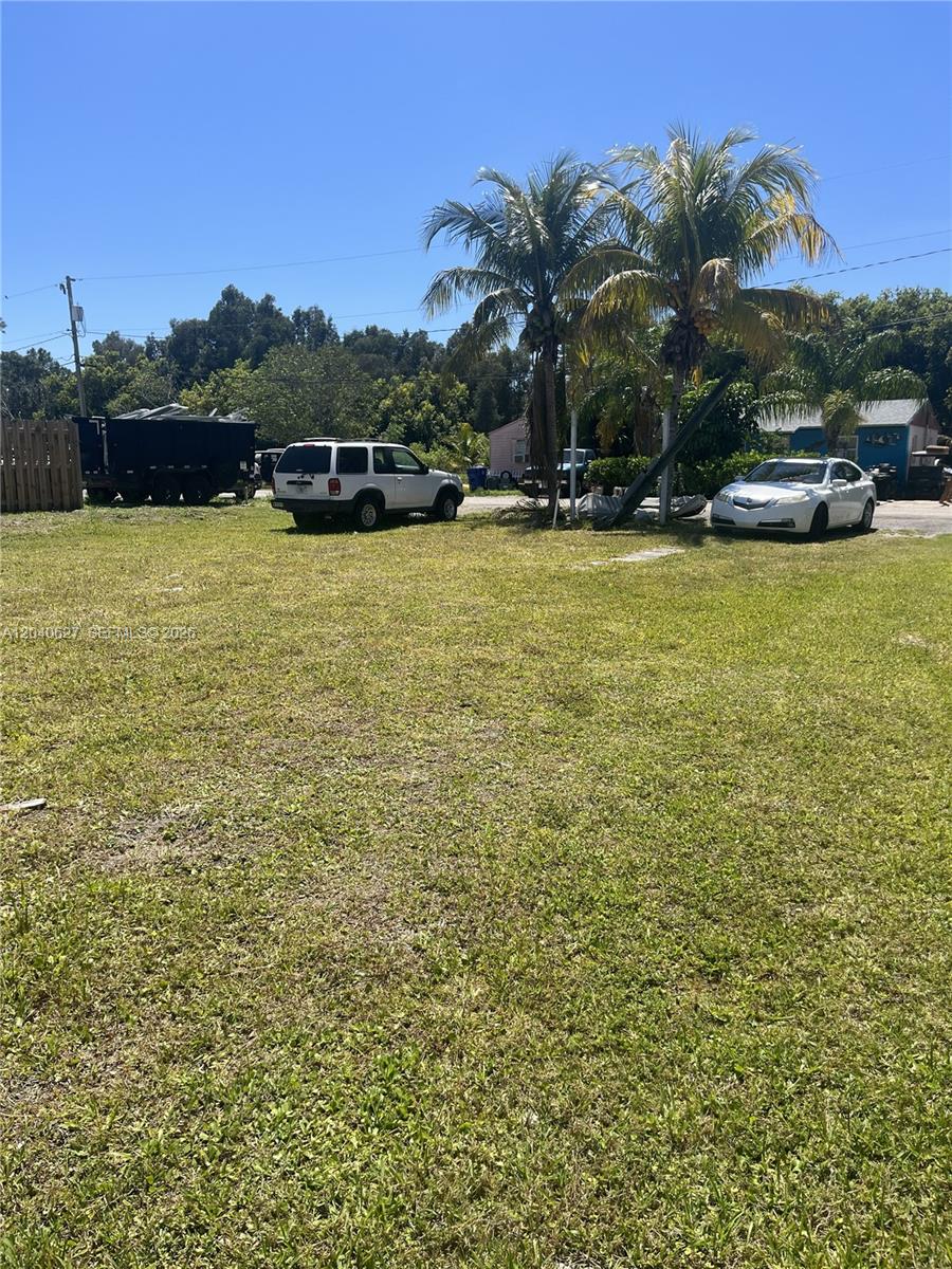A grassy lot features two palm trees, a white SUV, and a white sedan — 5754 SE Green Ln, Stuart FL 34997, STUART, FL
