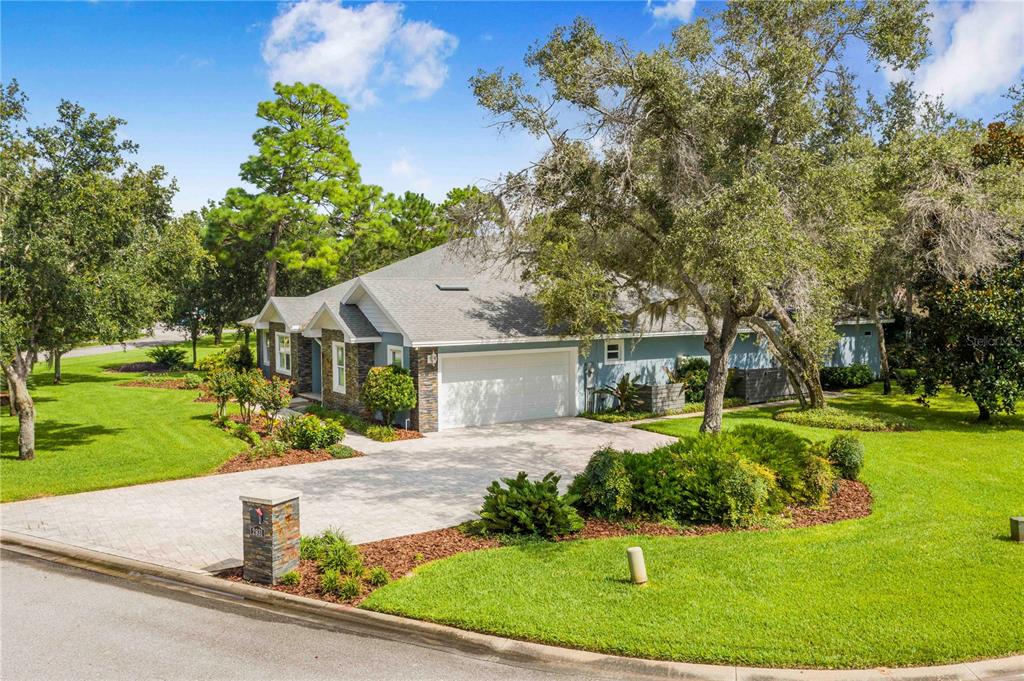 A blue single-story house with a stone facade, a two-car garage, and a paved driveway — 2931 CHICKASAW CIRCLE, HAINES CITY, FL