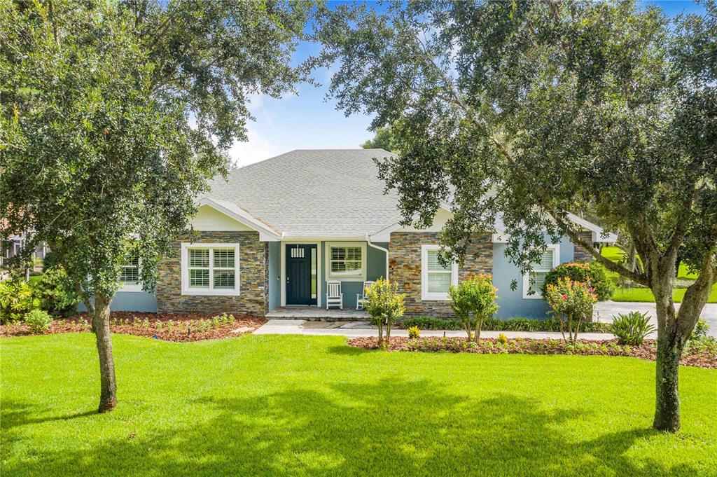 A single-story house with stone veneer siding, a dark front door, and a grassy lawn — 2931 CHICKASAW CIRCLE, HAINES CITY, FL