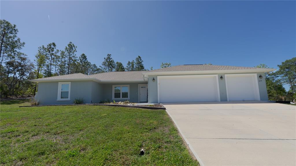 A light blue single-story house with a two-car garage and a concrete driveway — 6374 W RIO GRANDE DRIVE, BEVERLY HILLS, FL