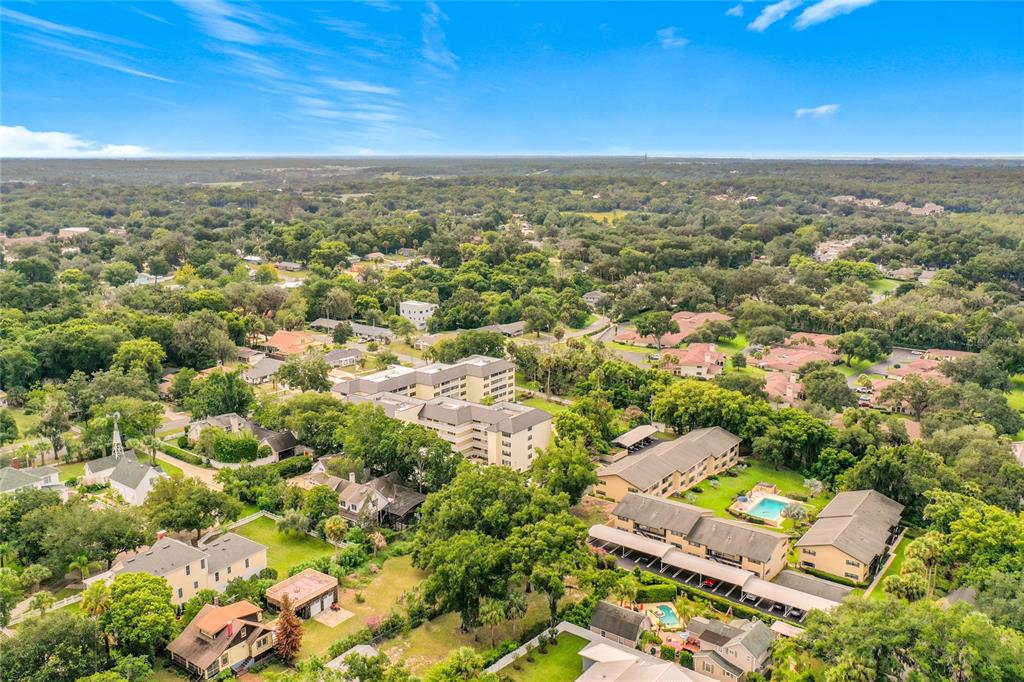 An aerial view shows a residential area with apartment buildings, houses, and surrounding trees — 101 N GRANDVIEW STREET, MOUNT DORA, FL