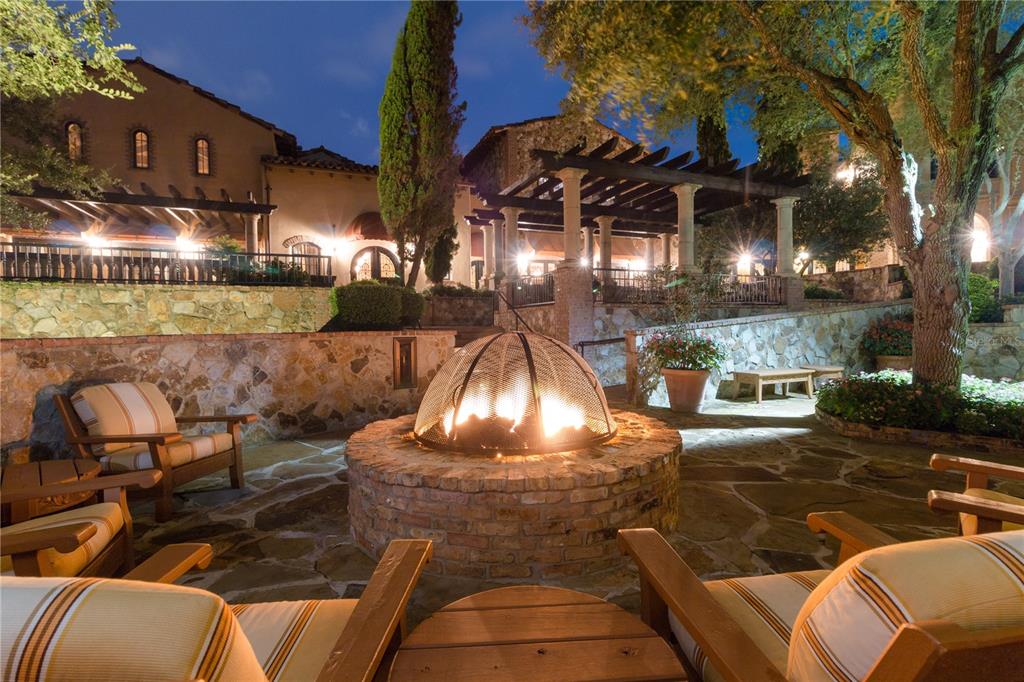 A stone patio features a circular brick fire pit with a mesh cover and lounge chairs — 16217 PENDIO DRIVE, MONTVERDE, FL