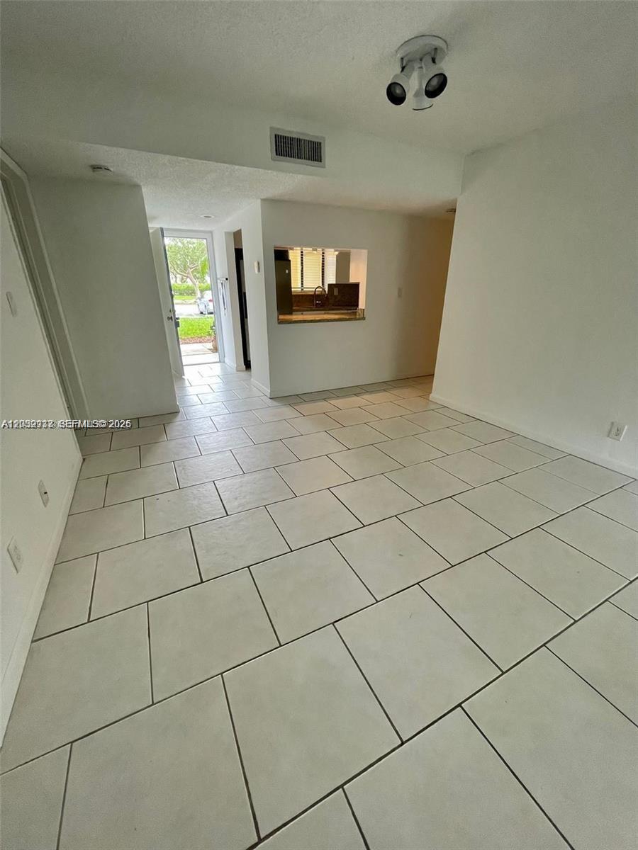 A bright, tiled dining area features a pass-through window looking into the kitchen — 183 Lakeview Dr # 103, Weston FL 33326, WESTON, FL