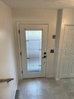 An interior entryway features a white front door with a frosted glass panel and tile flooring — 2112 NE 38TH AVENUE, OCALA, FL
