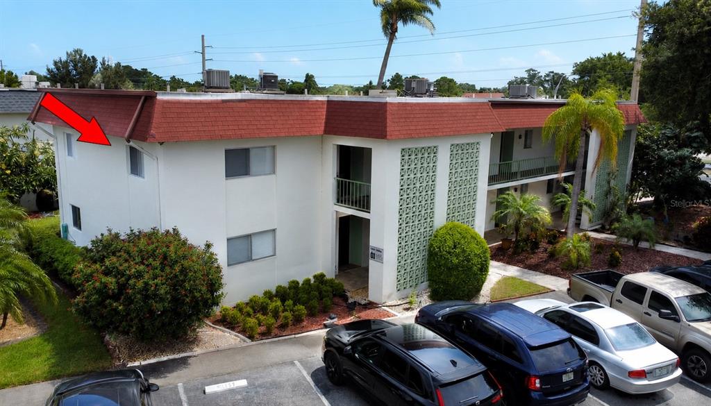 An exterior view of a two-story apartment building with a red shingled roof — 3606 BENEVA ROAD UNIT 504, SARASOTA, FL