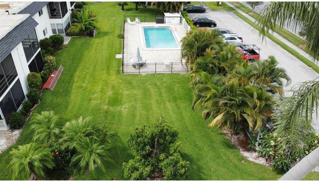 An aerial view shows a swimming pool, a grassy lawn, palm trees, and a parking lot — 3606 BENEVA ROAD UNIT 504, SARASOTA, FL