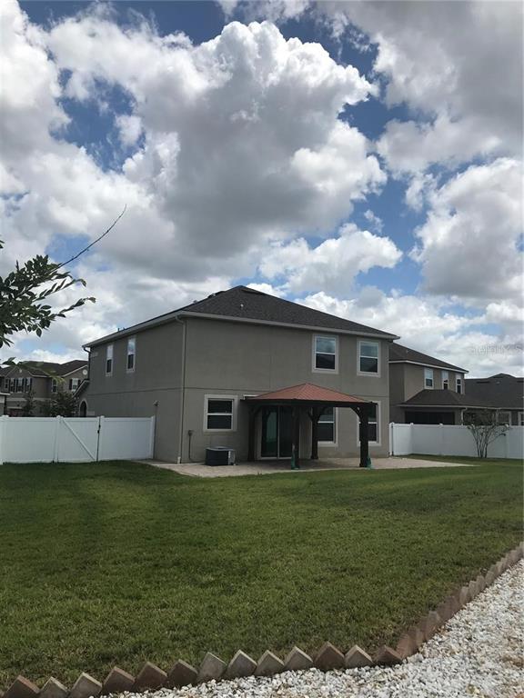 The exterior of a two-story house features a backyard patio with a covered pergola — 2504 AMATI DRIVE, KISSIMMEE, FL