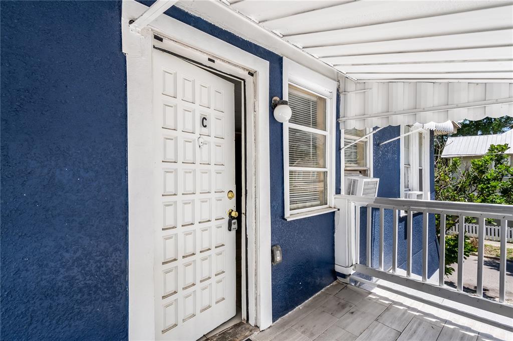 A blue exterior wall features a white door labeled C and a covered porch area — 418 E AMELIA AVENUE UNIT C, TAMPA, FL