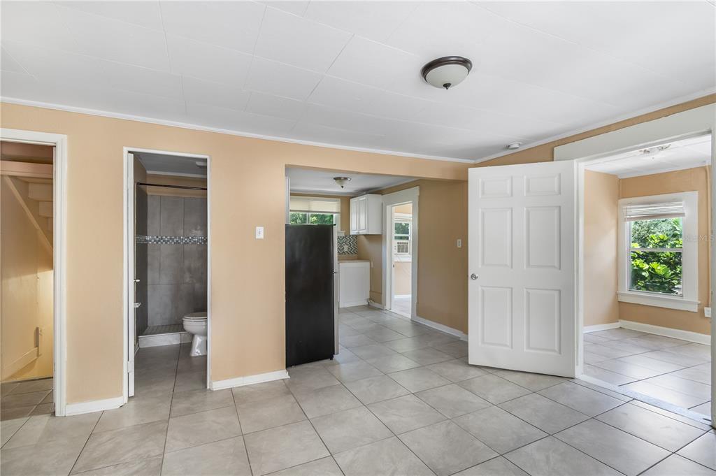 A tiled room features a bathroom, a black refrigerator, and an open doorway to another space — 418 E AMELIA AVENUE UNIT C, TAMPA, FL
