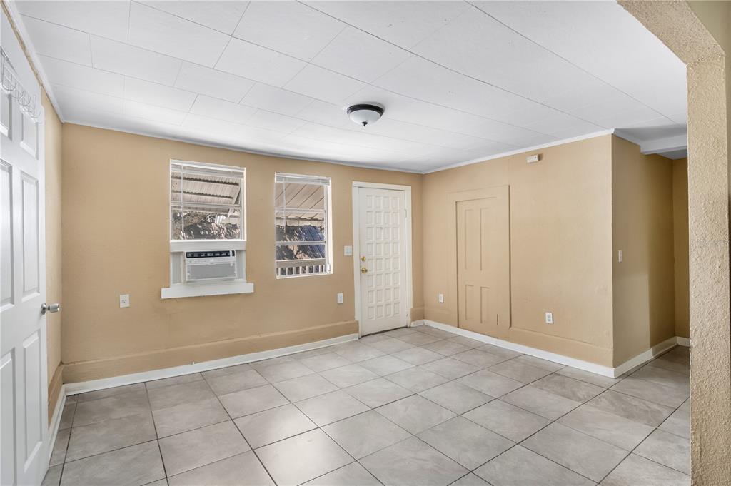 A room with beige walls, tile flooring, a white ceiling, two windows, and two doors — 418 E AMELIA AVENUE UNIT C, TAMPA, FL