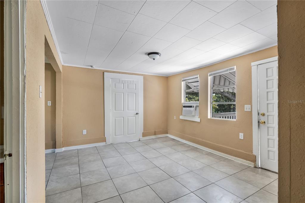 A sunroom with tan walls, white tile flooring, a white ceiling, and two exterior doors — 418 E AMELIA AVENUE UNIT C, TAMPA, FL