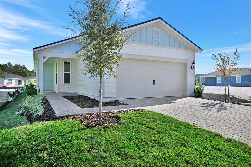 A single-story house with white siding, a two-car garage, and a paved driveway — 343 FISHTAIL PLACE, PALM COAST, FL