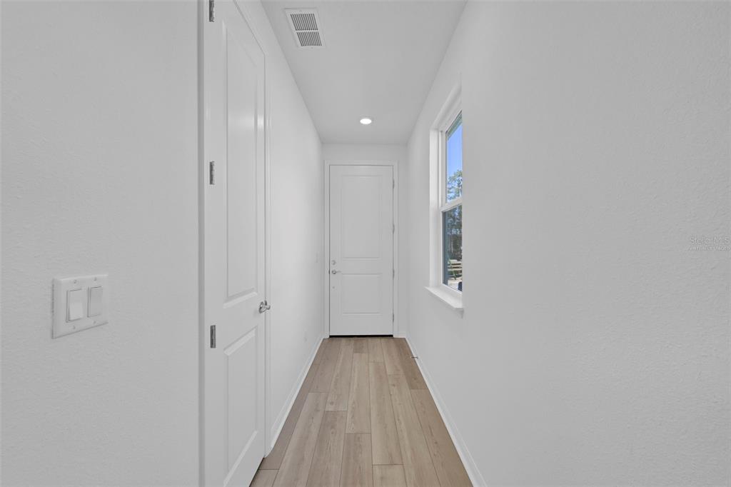 A narrow hallway features white walls, light wood-look flooring, and two white interior doors — 343 FISHTAIL PLACE, PALM COAST, FL