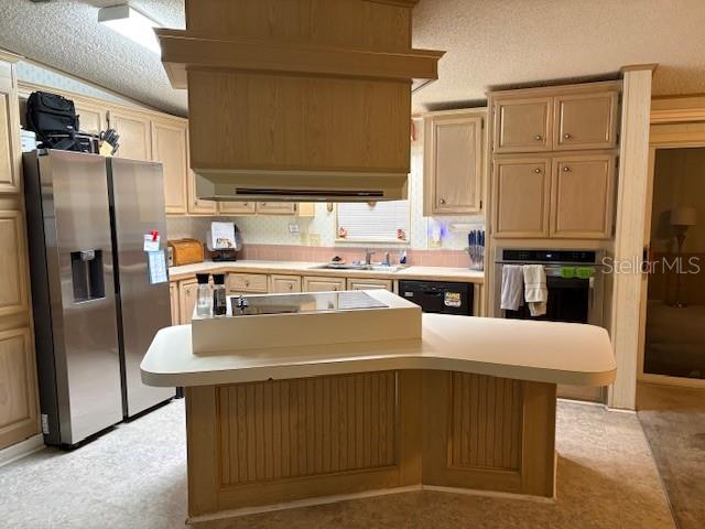 A kitchen features light wood cabinets, a stainless steel refrigerator, and a central island — 4412 TEKA LANE, ST CLOUD, FL