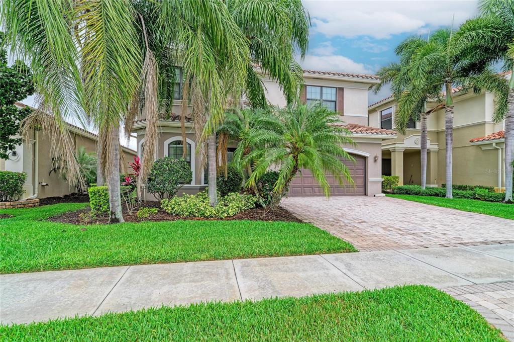 A two-story suburban house features a paved driveway, palm trees, and a tiled roof — 3701 PLEASANT SPRINGS DRIVE, NAPLES, FL
