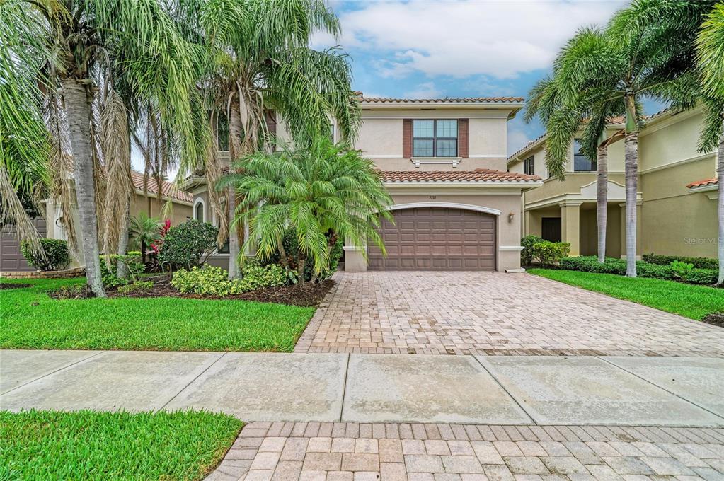 A two-story stucco house with a tiled roof, a paved driveway, and palm trees — 3701 PLEASANT SPRINGS DRIVE, NAPLES, FL