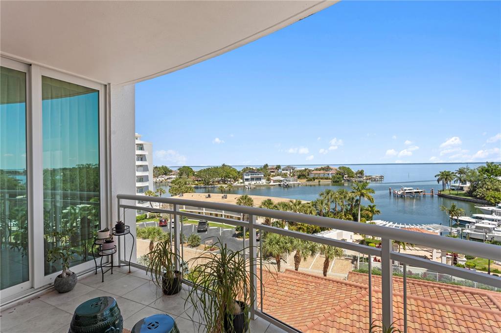 A balcony with a metal railing overlooks a coastal waterway, palm trees, and boats — 1325 SNELL ISLE BOULEVARD NE UNIT 507, ST PETERSBURG, FL