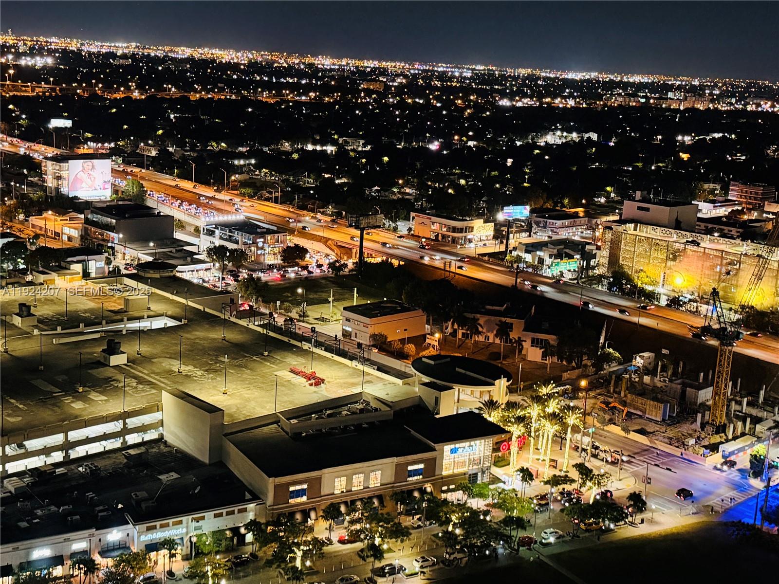 An aerial night view shows a shopping center, parking garage, and a busy highway — 121 NE 34th St # 3014, Miami FL 33137, MIAMI, FL
